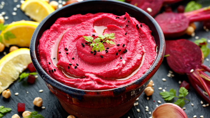 A bright vibrant bowl of smooth magenta beetroot hummus