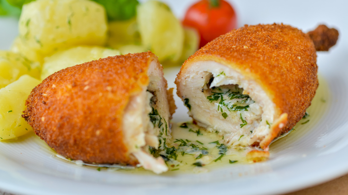 A halved breaded chicken Kyiv filled with a rich garlic sauce