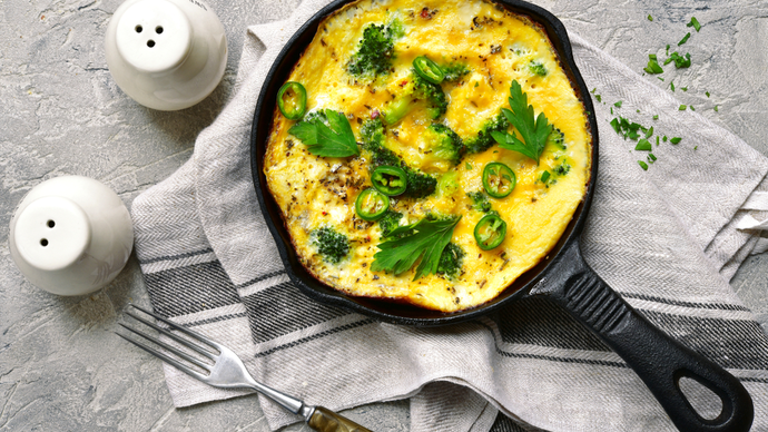 a vibrant yellow omelette topped with a green garnish
