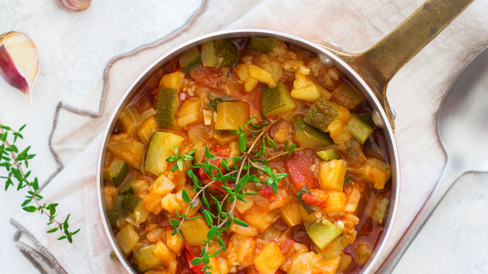 a thick stew of mixed soft vegetables including courgette and onion topped with fresh thyme