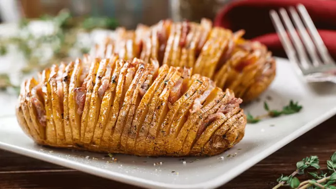 Tatws Hasselback pob euraidd wedi’u tafellu, gyda darnau o facwn ar eu pennau