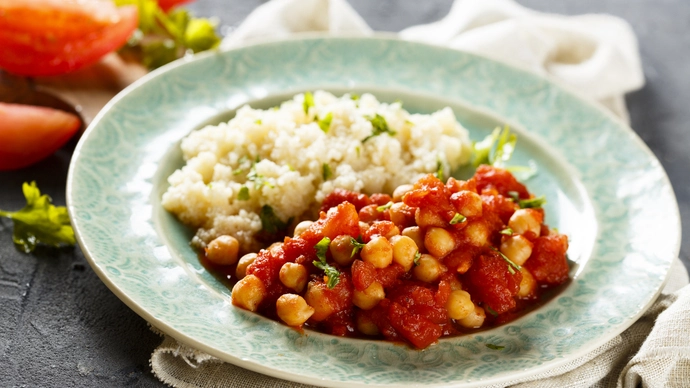 A plate of vibrant turkey tagine served with white rice and peas