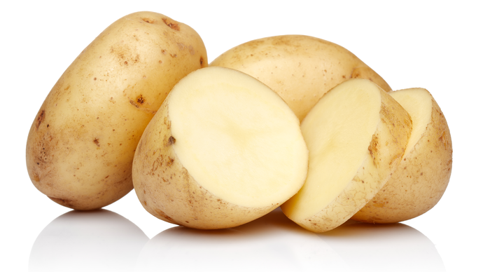 a small pile of raw unpeel potatoes