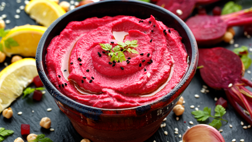 A bright vibrant bowl of smooth magenta beetroot hummus