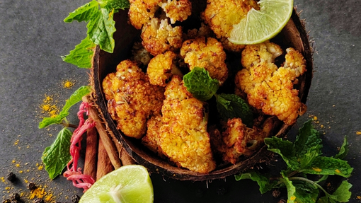 Roasted cauliflower with an orange tahini dressing and lime garnishes