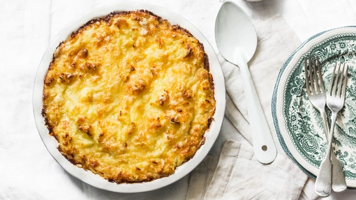 Golden potato topped masala fish pie in a ceramic dish