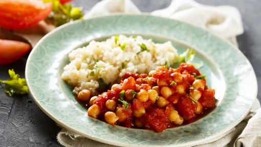 A plate of vibrant turkey tagine served with white rice and peas