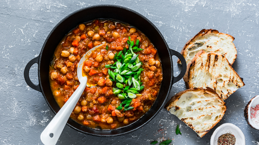 Black cooking pot full of chickpea and mushroom stew