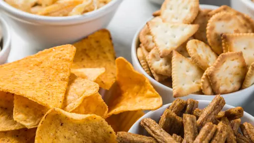 A selection of savoury snacks in small white ceramic bowls.